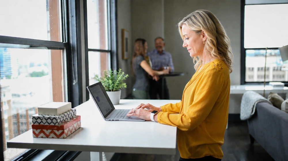 Eine Frau, 50 Plus und Digital fit, tippt auf einem Laptop